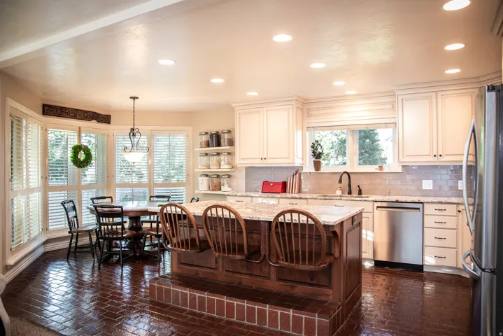 Kitchen featuring a central island with a multi-level wood finish, light-colored cabinetry, stainless steel appliances, and recessed lighting