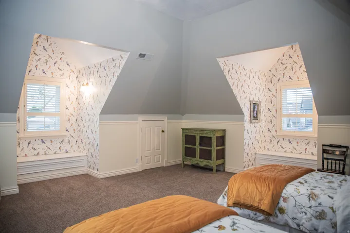 Bedroom has two dormer windows with window seats.