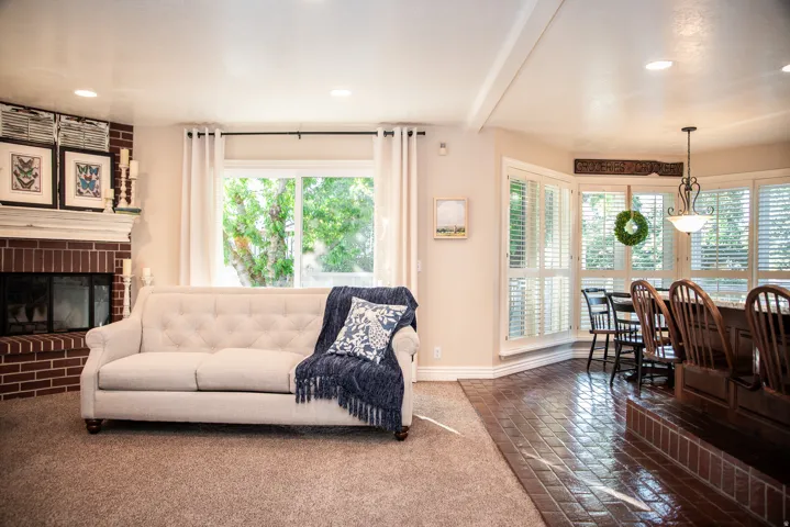 Living area featuring a brick fireplace with a white mantel and a sliding glass door to back deck