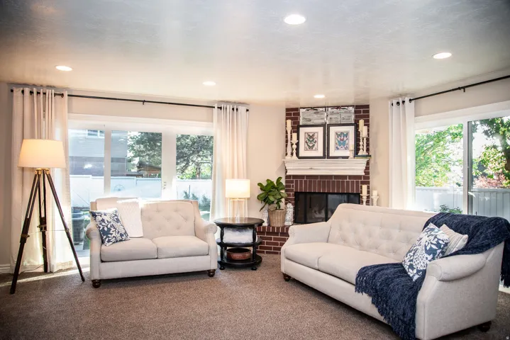 Living area featuring a brick fireplace with a white mantel, recessed lighting, and sliding glass doors to back deck