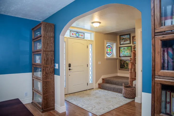 Entryway featuring a white paneled front door with decorative glass inserts and transom