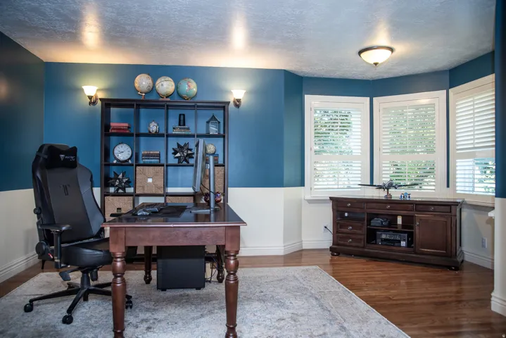 Dedicated room featuring partial blue walls and white wainscoting.  Formal living room or office space