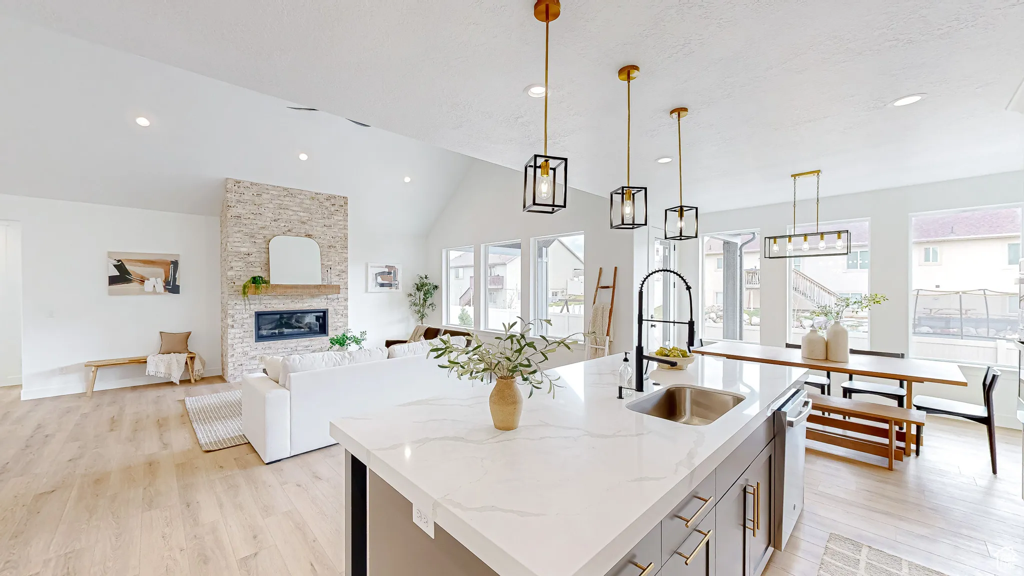 Open-concept living space featuring a vaulted ceiling and light wood-finish flooring