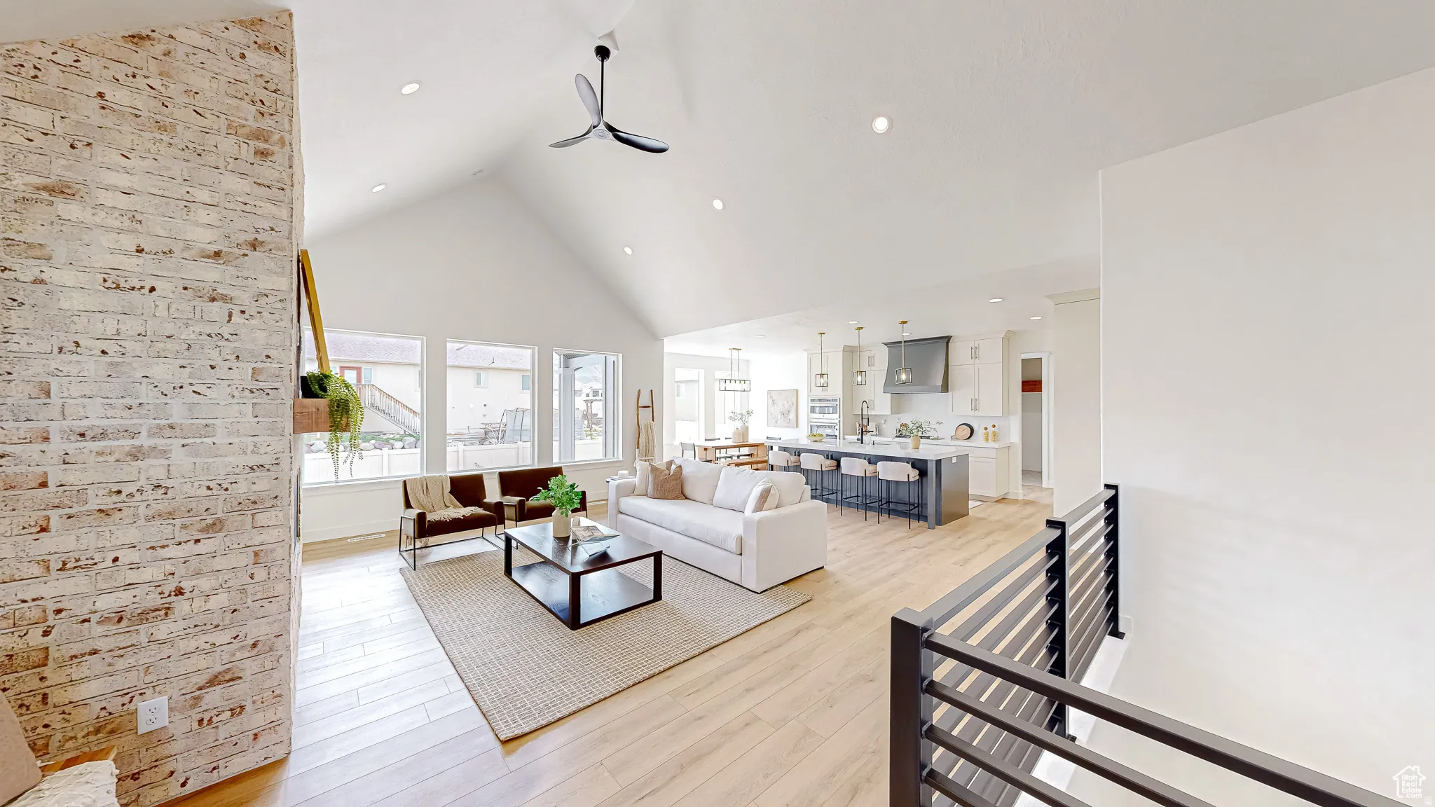 Spacious open-concept interior featuring light wood-finish flooring, a vaulted ceiling, and recessed lighting