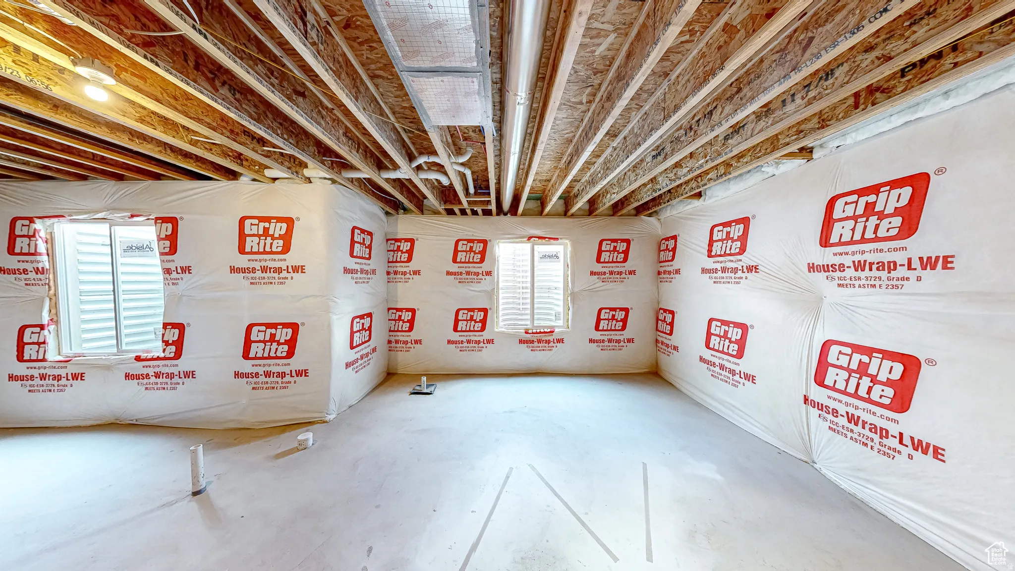 Unfinished basement space featuring exposed wood joists and concrete flooring