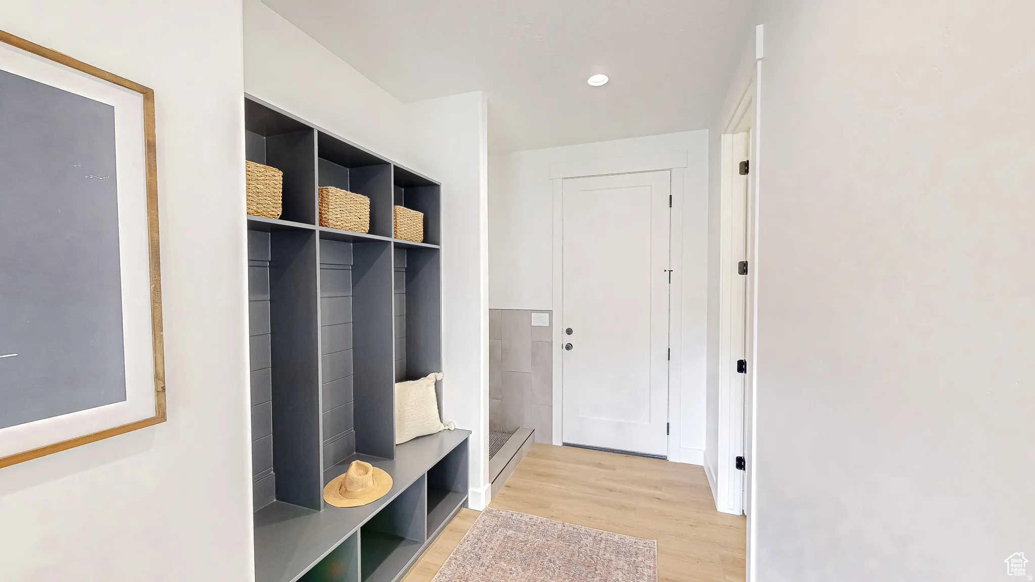 Entryway featuring built-in gray storage cubbies with bench seating