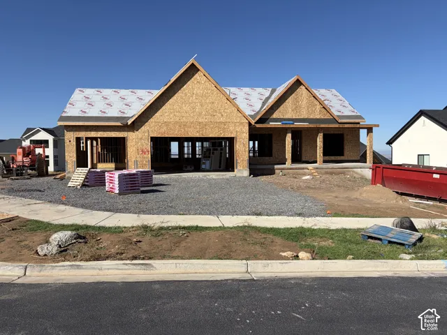 New construction featuring an expansive gable roofline, structural framing, and a covered entry
