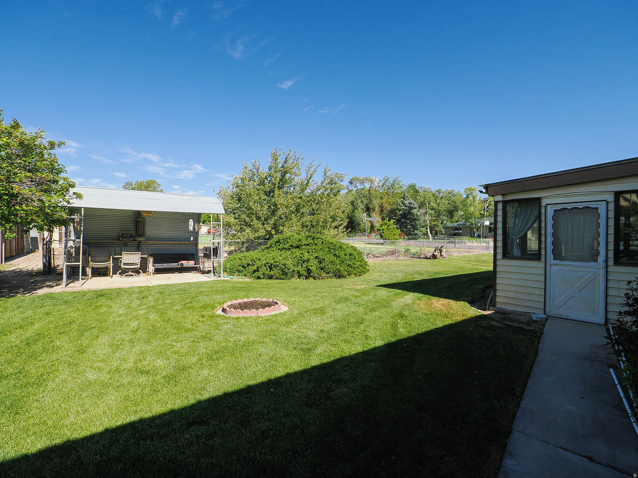 Expansive green lawn with a dedicated fire pit area