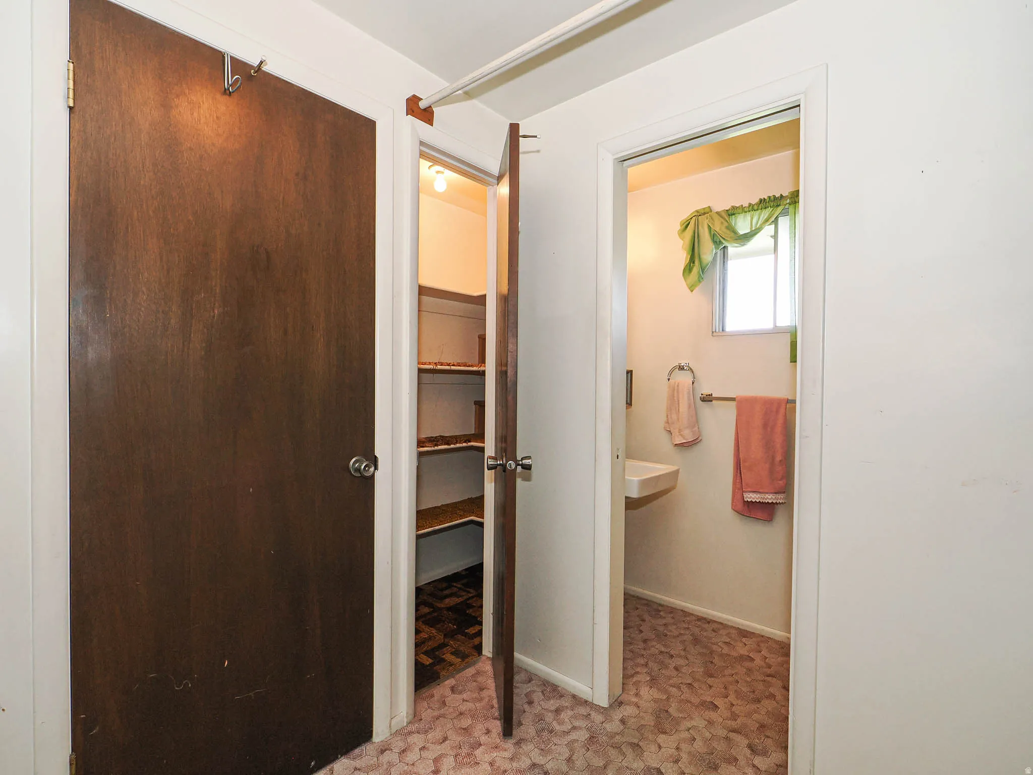 Bathroom with wall-mounted sink, window, and patterned floor