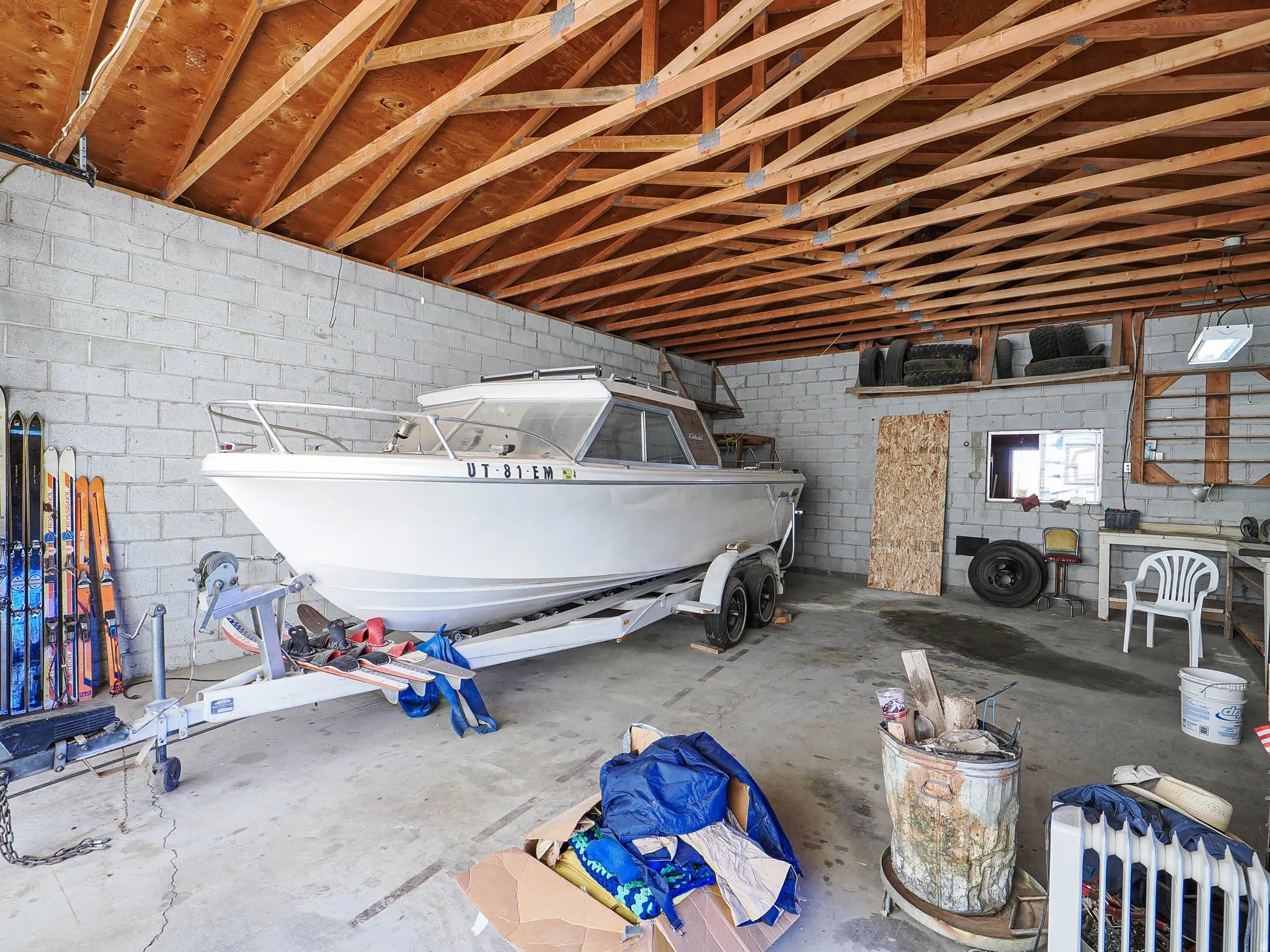Spacious enclosed storage area featuring concrete block walls and an exposed wood beam ceiling