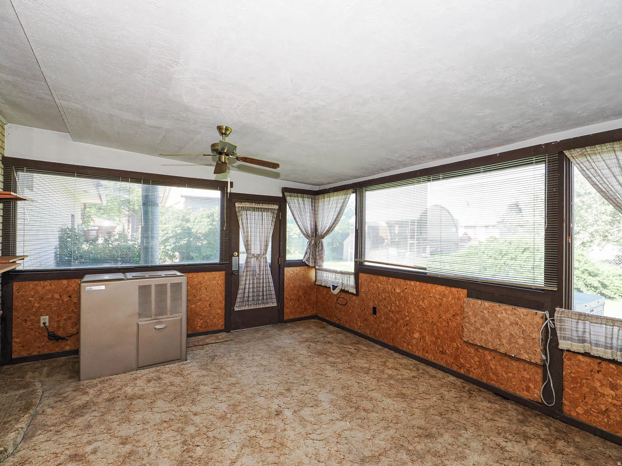 Room with expansive windows, a brown door, and brown trim