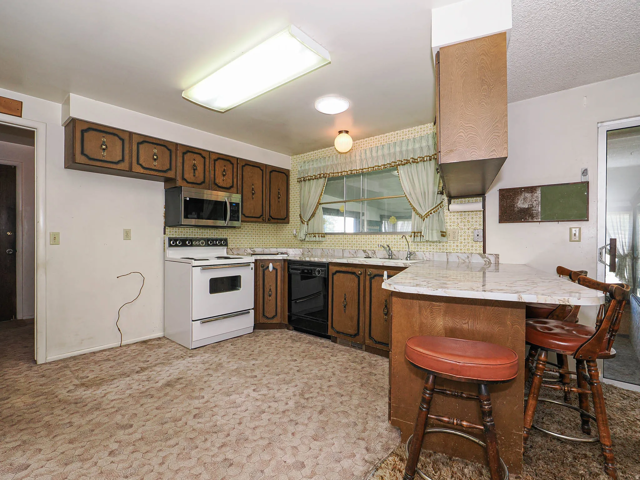 Kitchen featuring wood-finish cabinetry, a freestanding range, and a built-in microwave