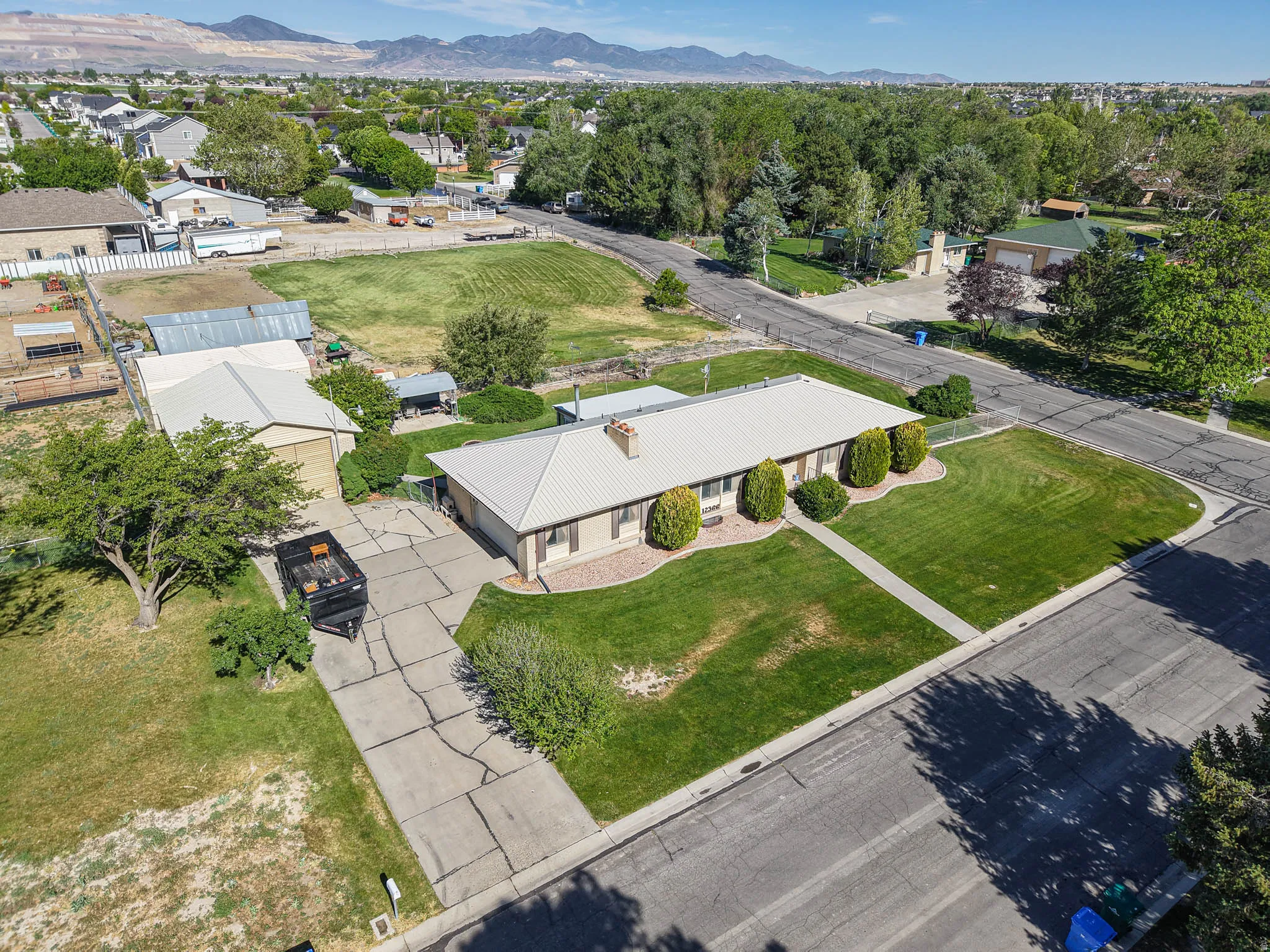 Single-story residence featuring a metal roof and a well-maintained front lawn with mature landscaping