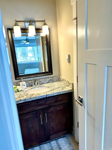 Bathroom vanity with a dark wood-finish cabinet and brushed nickel hardware