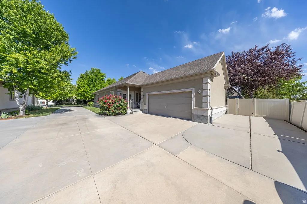 Spacious concrete driveway leading to a two-car garage