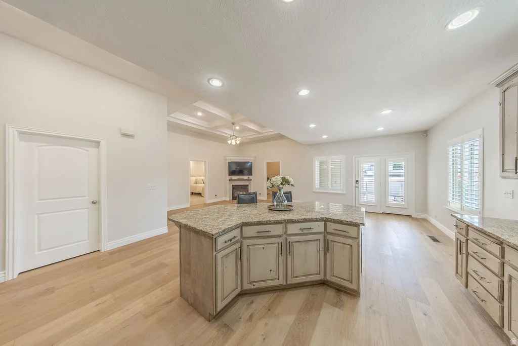 Spacious kitchen island with granite countertop and distressed cabinetry