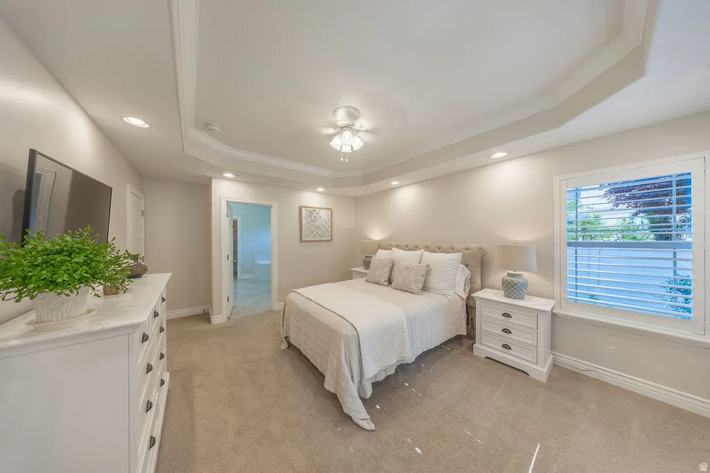 Spacious room featuring a tray ceiling with crown molding, recessed lighting, and a ceiling fan