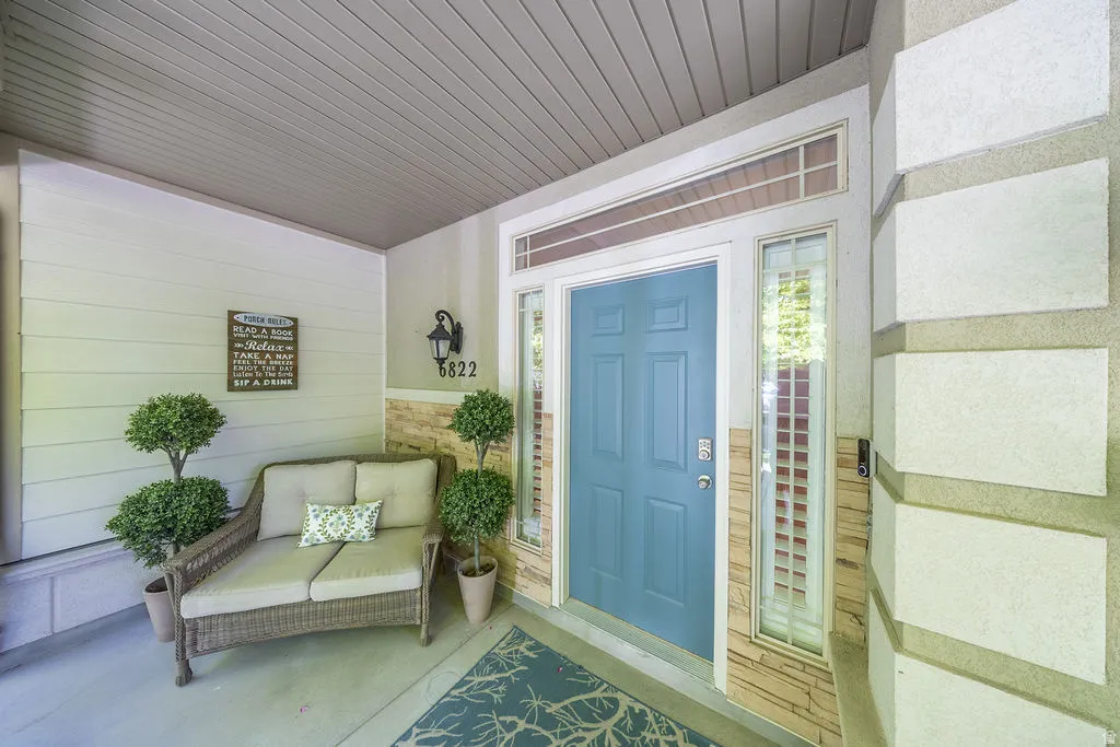 Covered front entry featuring a paneled door, transom window, and sidelight