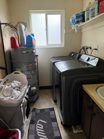 Laundry area featuring a sliding window with frosted glass, built-in shelving, and a utility sink with cabinetry