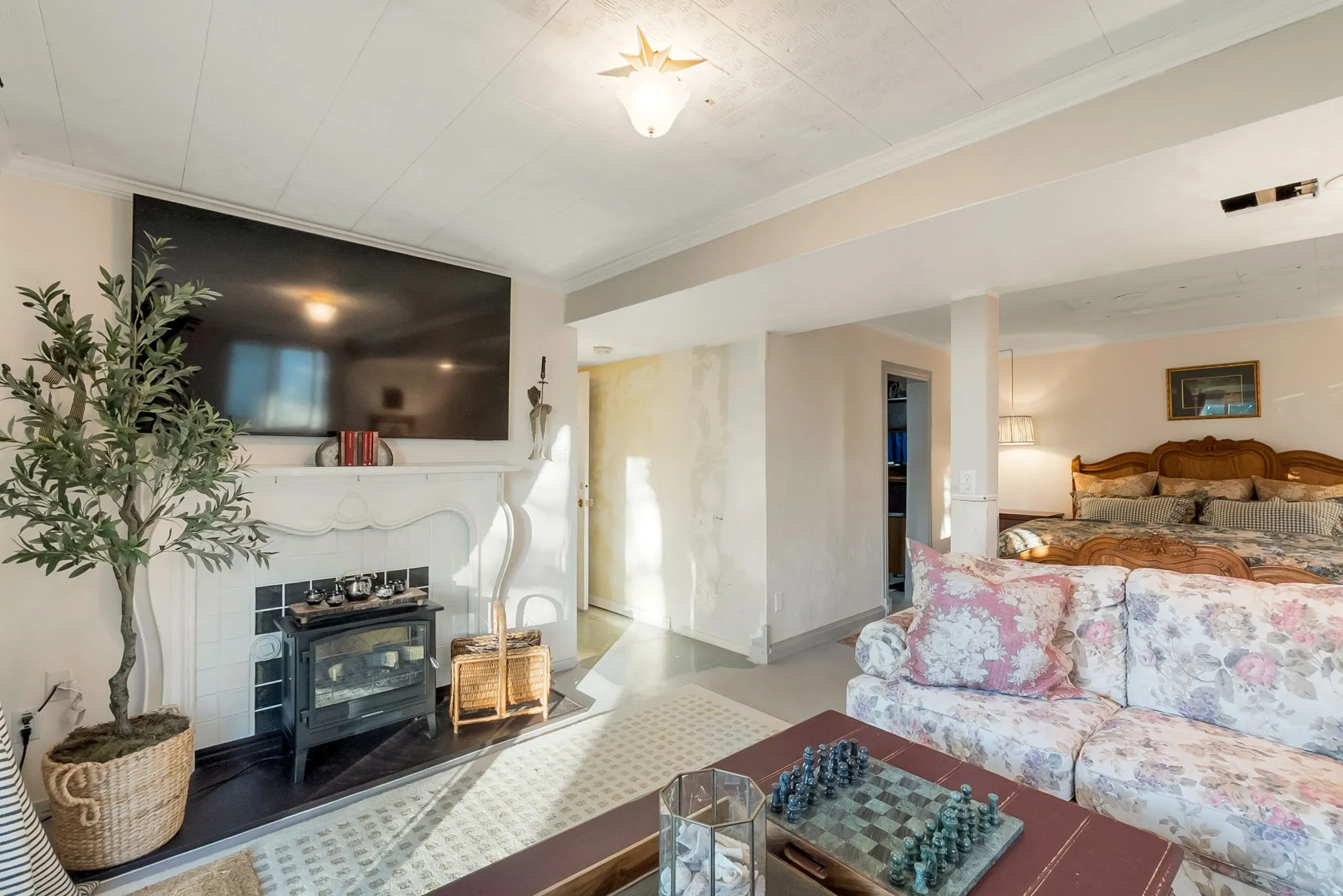 Living area featuring a white mantel, black tile hearth, and a built-in wood-burning stove