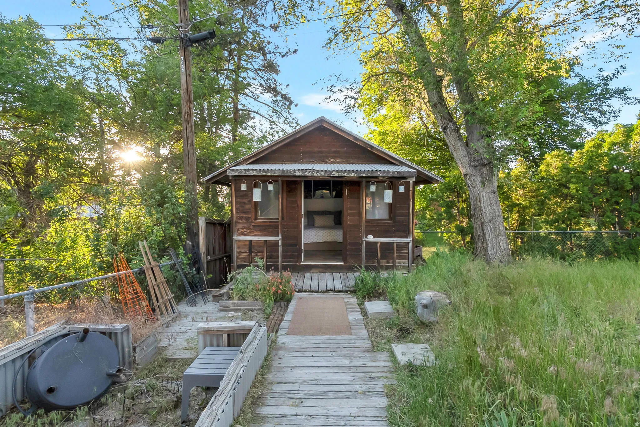 Wood-sided structure featuring a covered front porch with decorative lighting