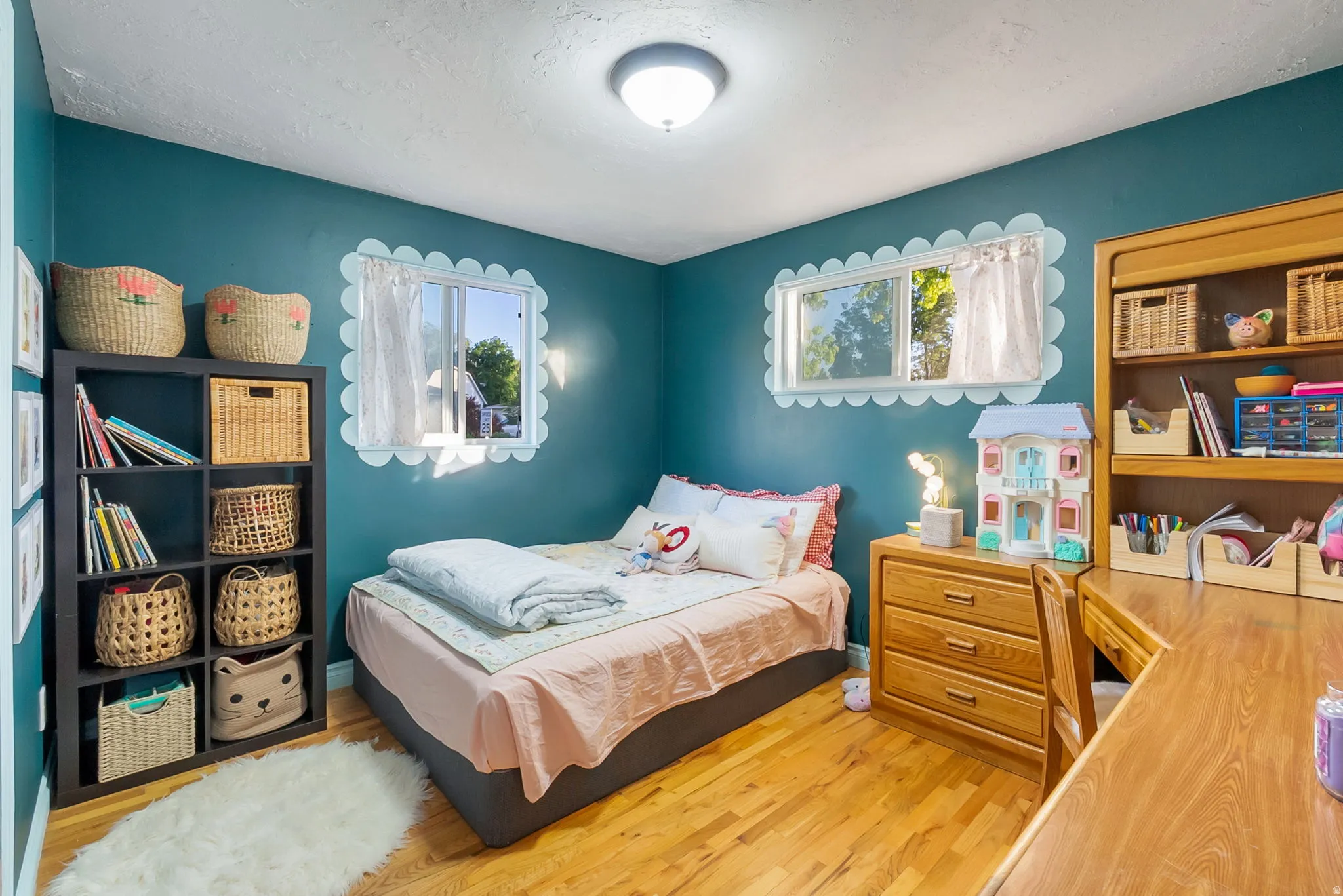 Room featuring wood-finish flooring, two rectangular windows, and a ceiling-mounted light fixture