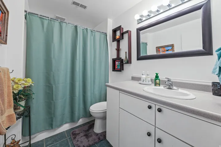 Bathroom featuring a full vanity with an integrated sink, polished chrome faucet, and ample under-sink storage