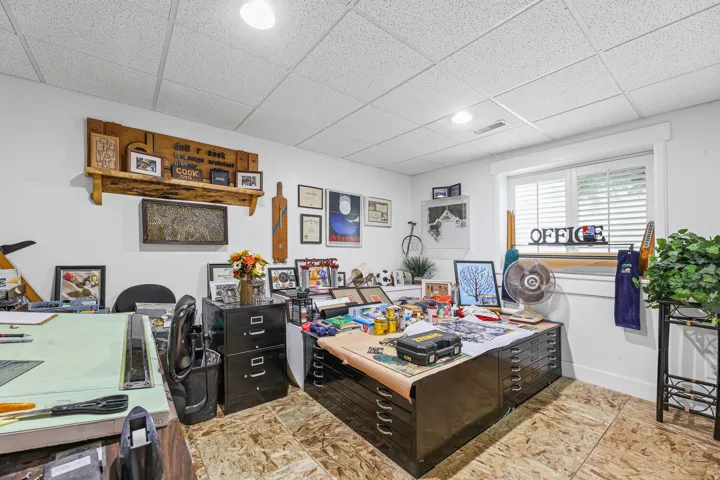 Finished room featuring white walls, a grid panel ceiling, and a large window with white blinds