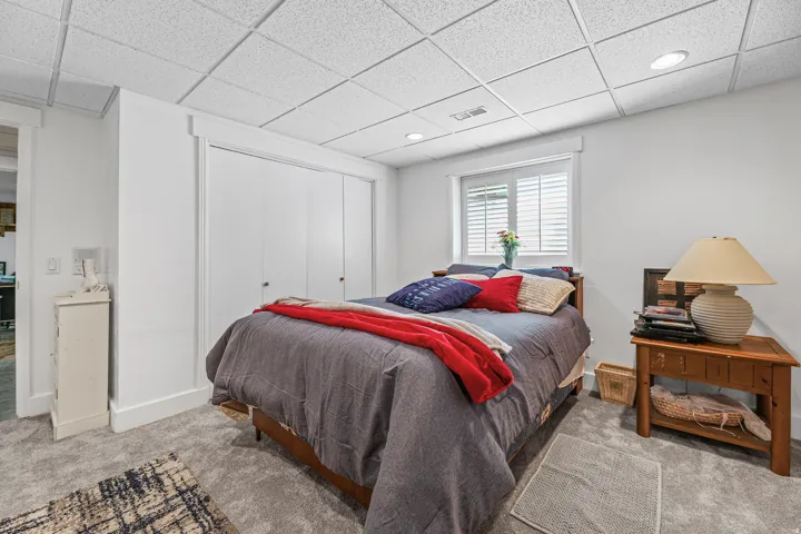 Carpeted room with a drop ceiling featuring recessed lighting
