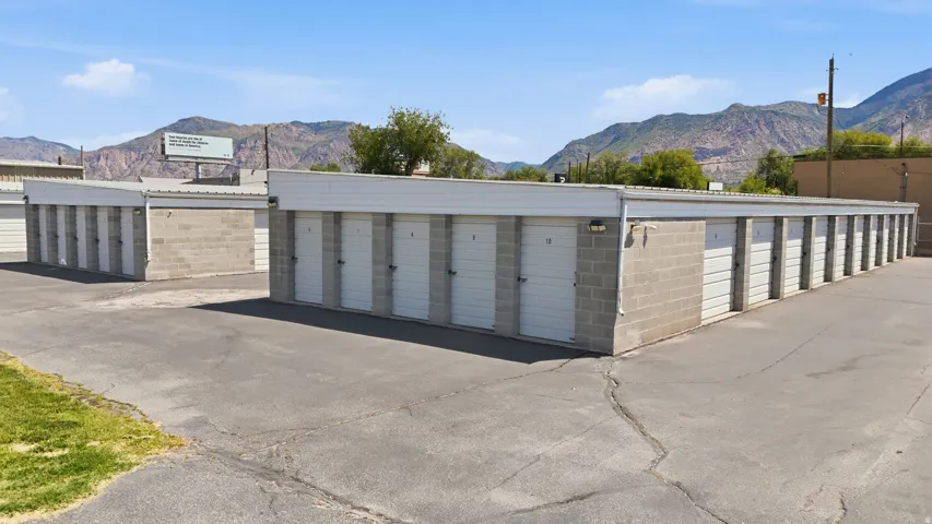 Storage facility featuring multiple units, block construction, roll-up doors, and an asphalt drive