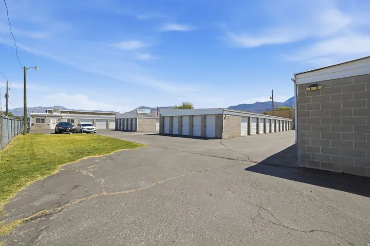 Multiple storage unit buildings featuring concrete block construction and white roll-up doors