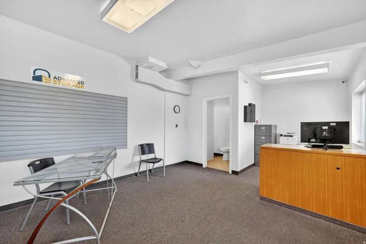 Office space featuring wood-finish reception counter, wall-to-wall carpeting, and recessed lighting