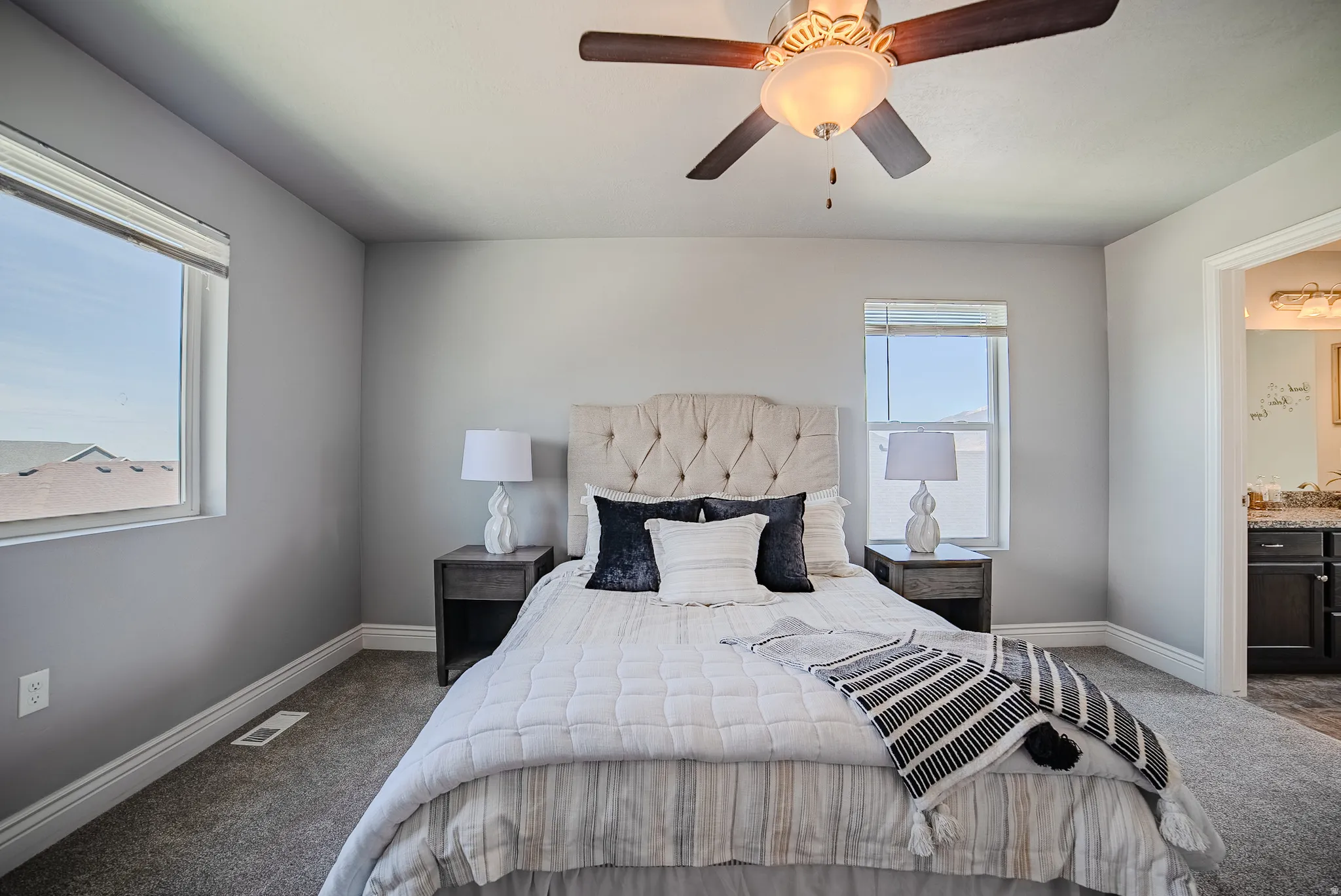 Bedroom featuring neutral gray wall paint, dark gray carpeting, and white baseboards