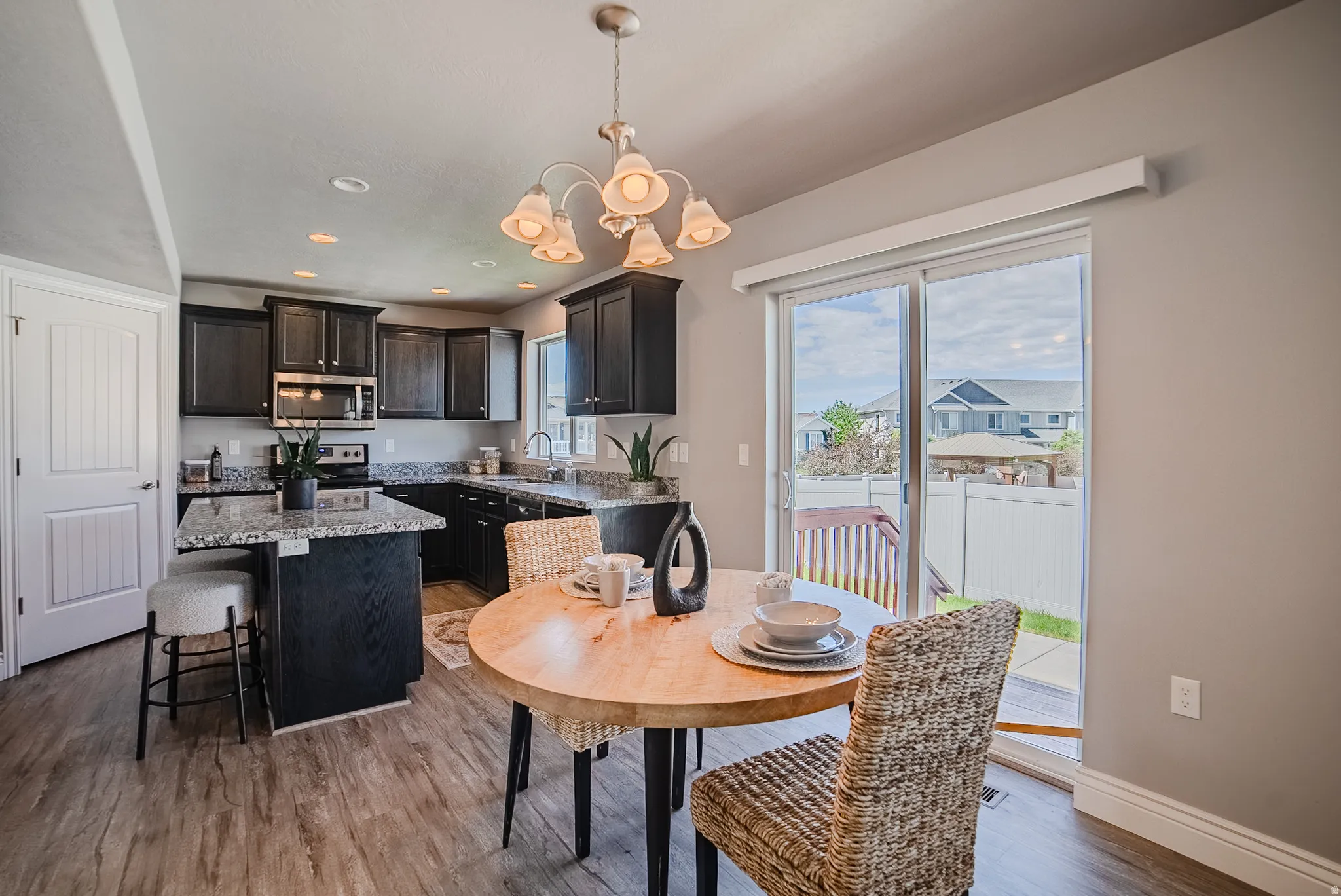 Modern kitchen featuring dark wood cabinetry, granite countertops, and stainless steel appliances