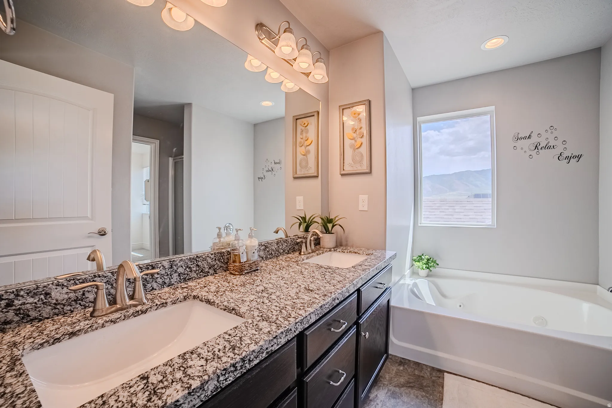 Bathroom featuring a double vanity with granite countertops, undermount sinks, and brushed nickel fixtures