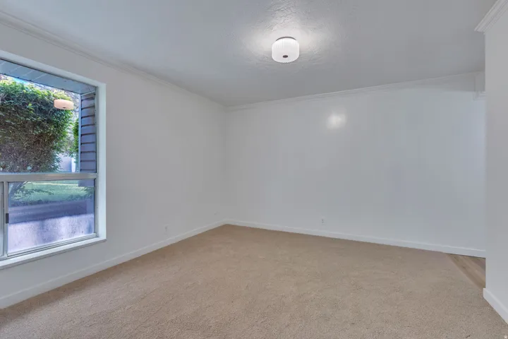 Spacious room featuring neutral carpeting and white wall finishes