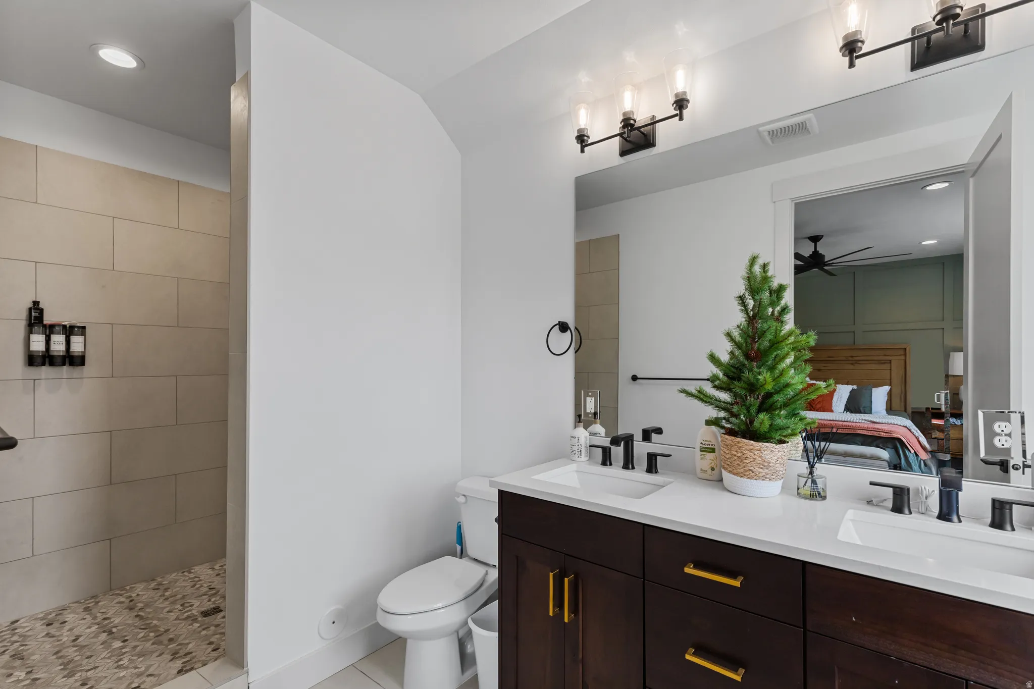 Dual vanity with dark wood cabinetry and gold-tone hardware