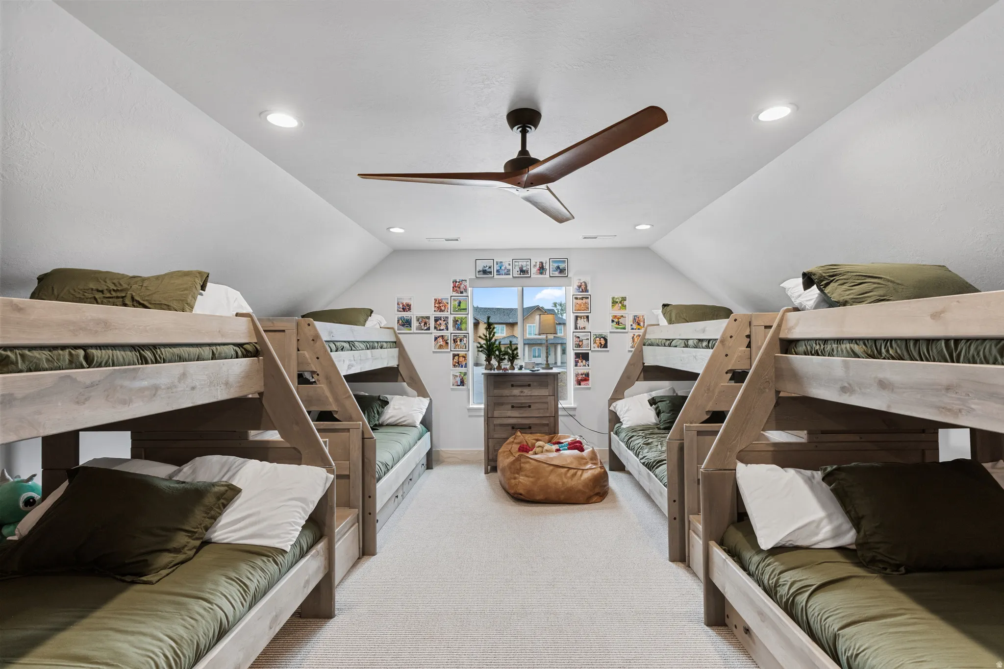 Spacious room featuring vaulted ceilings, recessed lighting, and a large ceiling fan