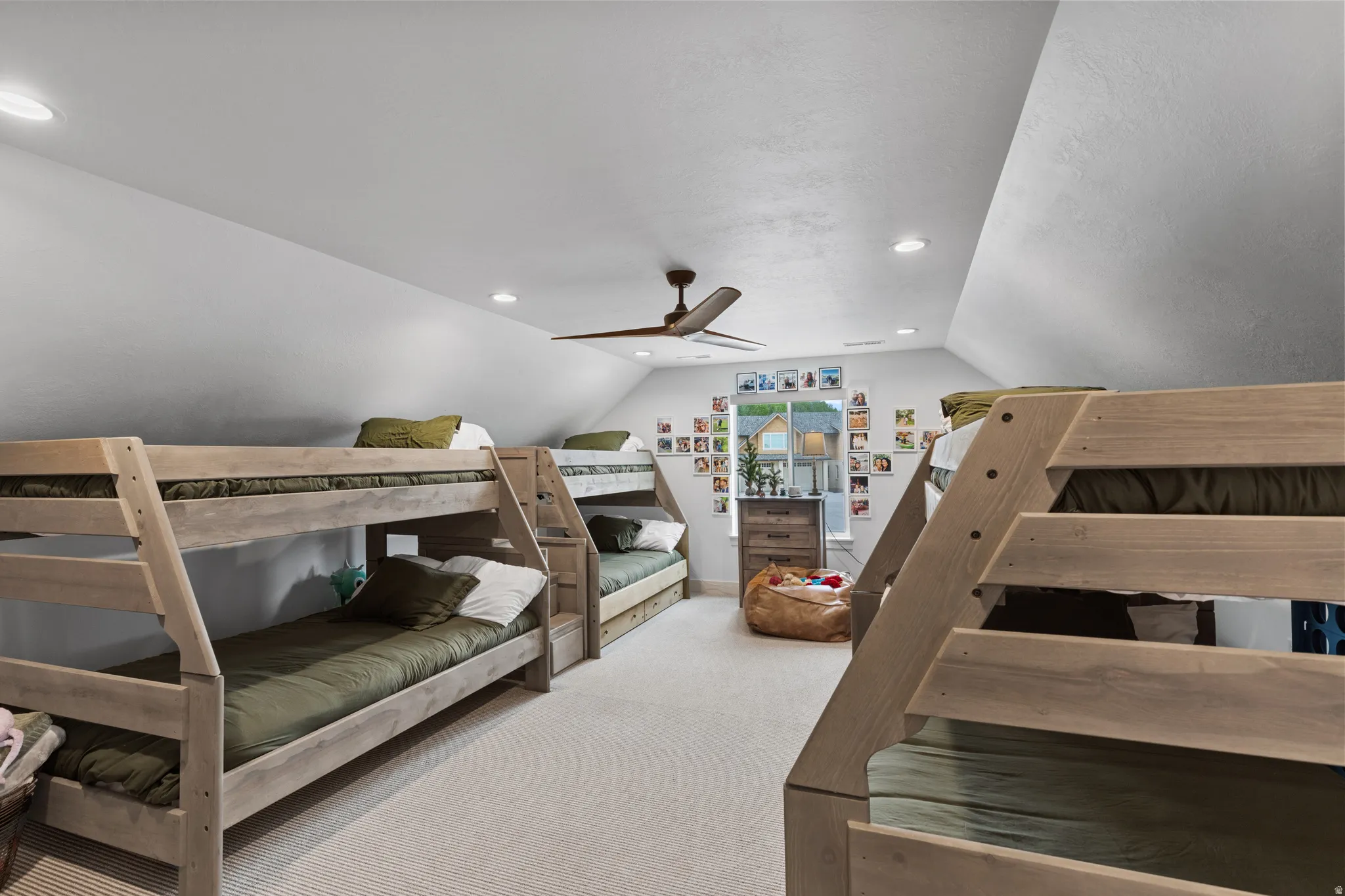 Vaulted ceiling room featuring multiple bunk beds with integrated stairs, recessed lighting, and a ceiling fan