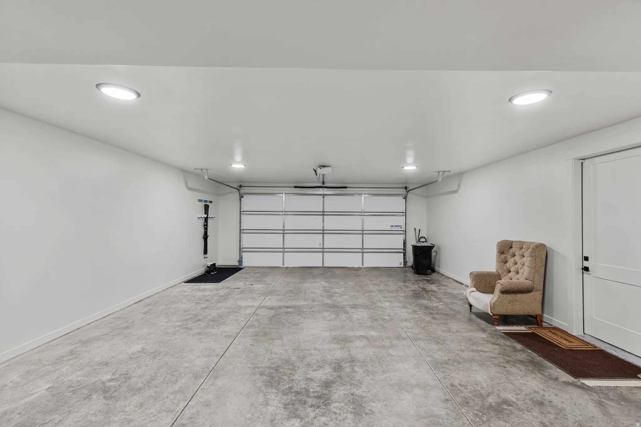 Spacious garage featuring a concrete floor, white walls, and bright recessed lighting