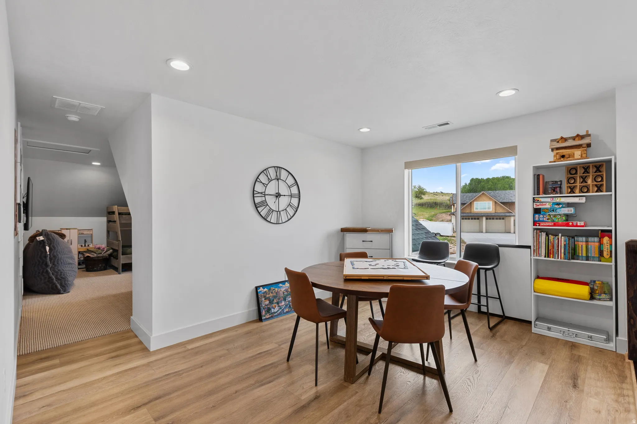 Bright room featuring wood-finish flooring, recessed lighting, and a large window with exterior views