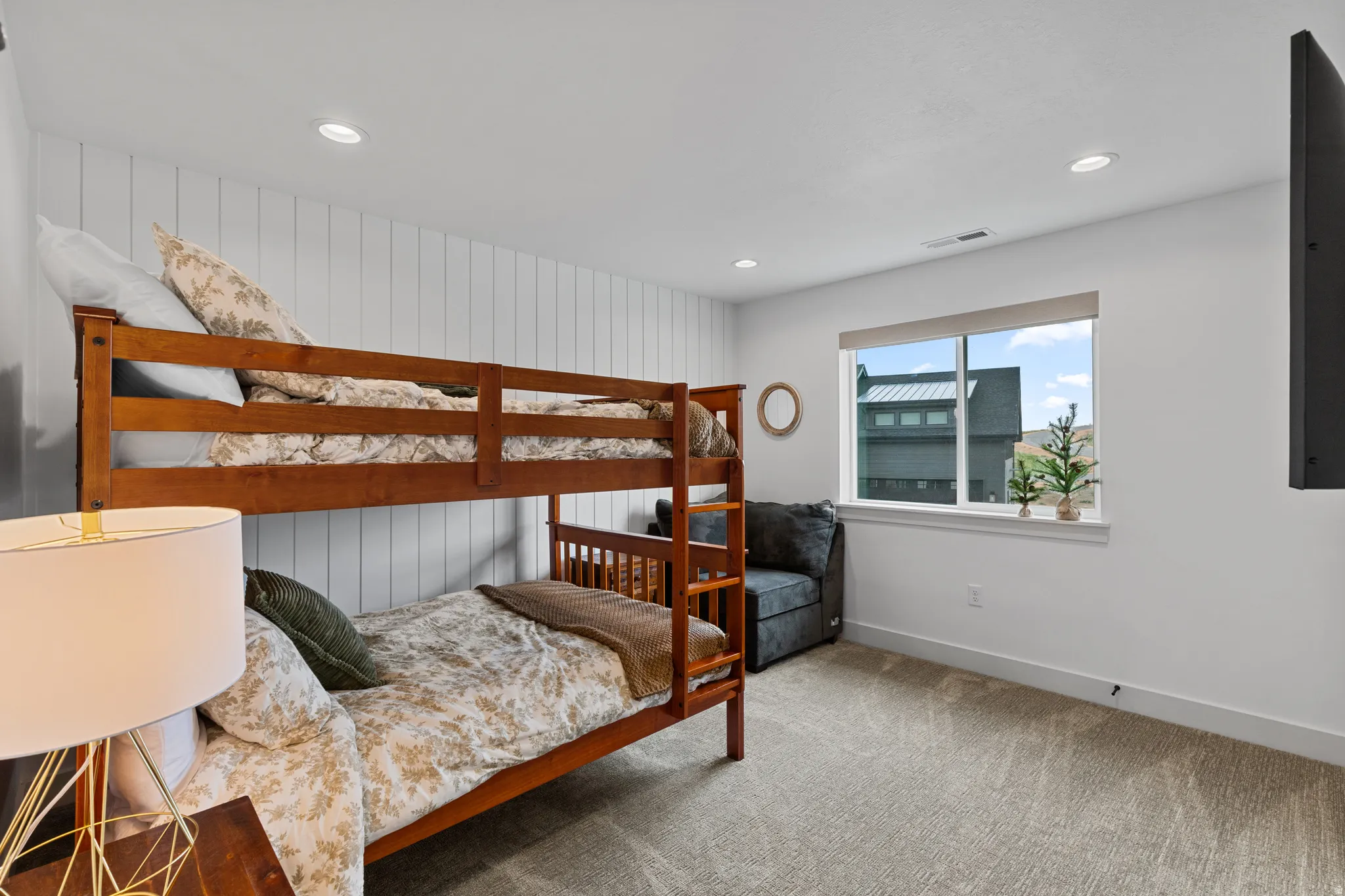 Carpeted room featuring a window with white trim, recessed lighting, and a vertical shiplap accent wall