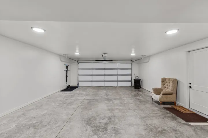 Spacious garage featuring a concrete floor, white walls, and bright recessed lighting