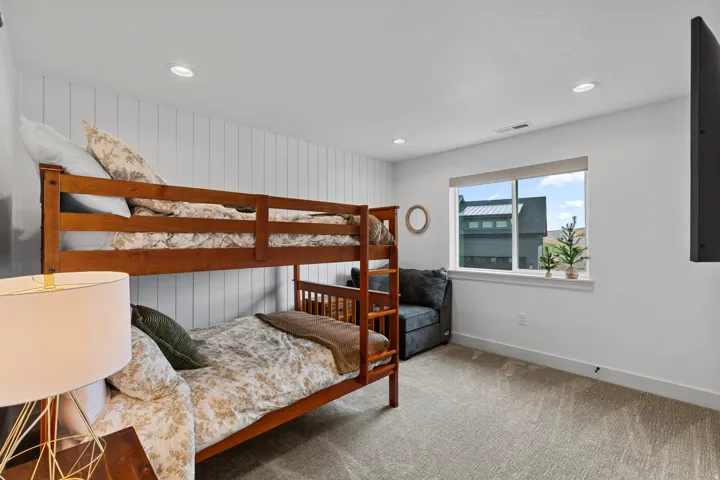 Carpeted room featuring a window with white trim, recessed lighting, and a vertical shiplap accent wall