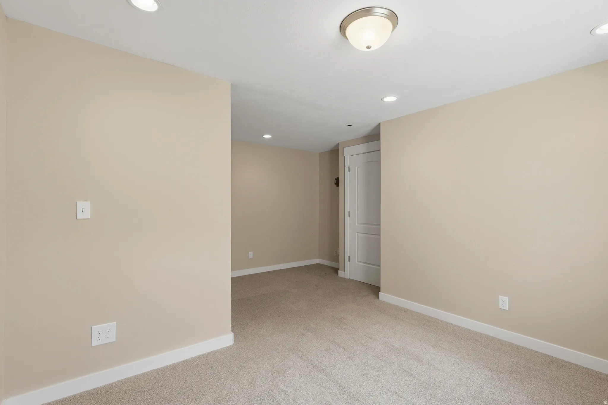 Spacious and light bedroom #4 with a large window and recessed and flush-mount lighting.