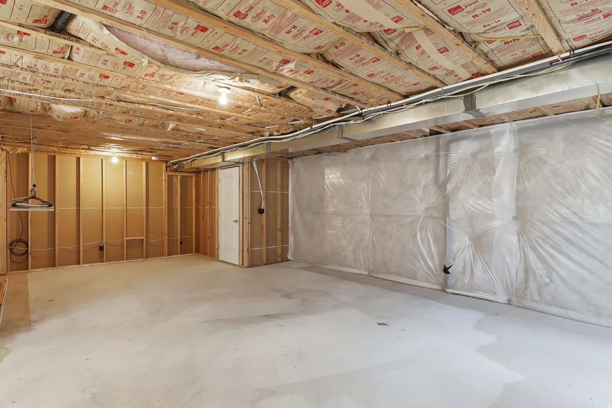Unfinished basement featuring insulation on walls and between levels in the ceiling. Room for a large family room and another bedroom.