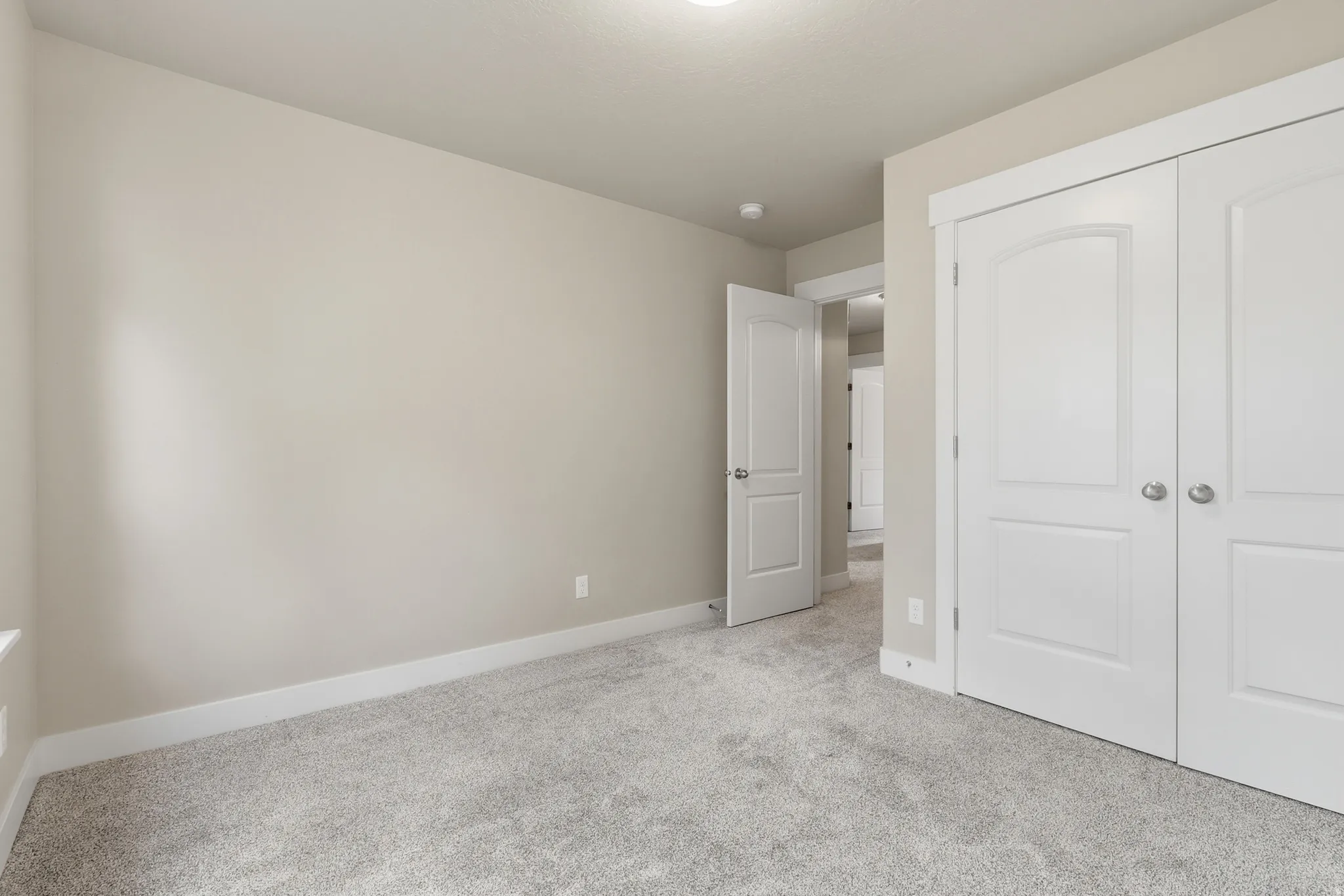 Spacious bedroom #3 featuring two large windows, light-colored carpeting, and a large closet.