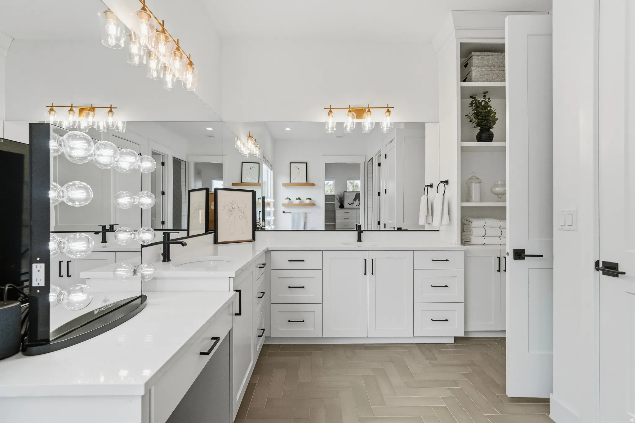 Spacious bathroom featuring a double vanity with stone countertops, white shaker cabinetry, and black fixtures.