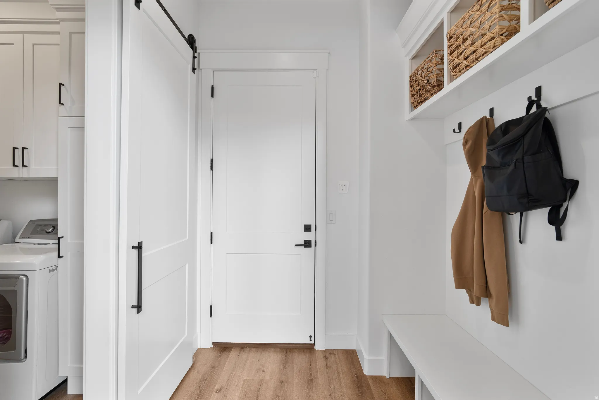 Entryway featuring built-in bench seating, upper open shelving, and coat hooks.