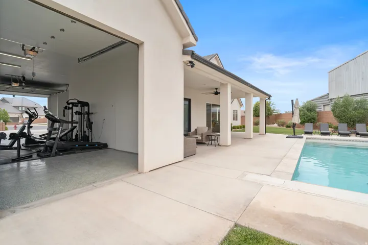 Outdoor living space featuring a covered patio, inground swimming pool, and concrete decking.
